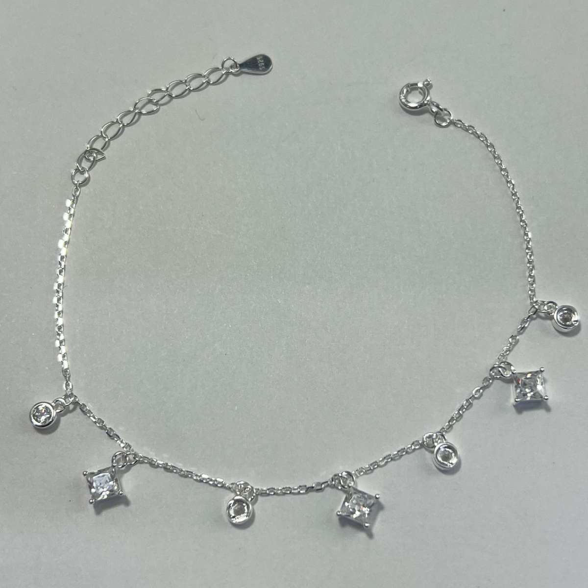 TOBILLERA EN PLATA CON DIJES DE CIRCONES